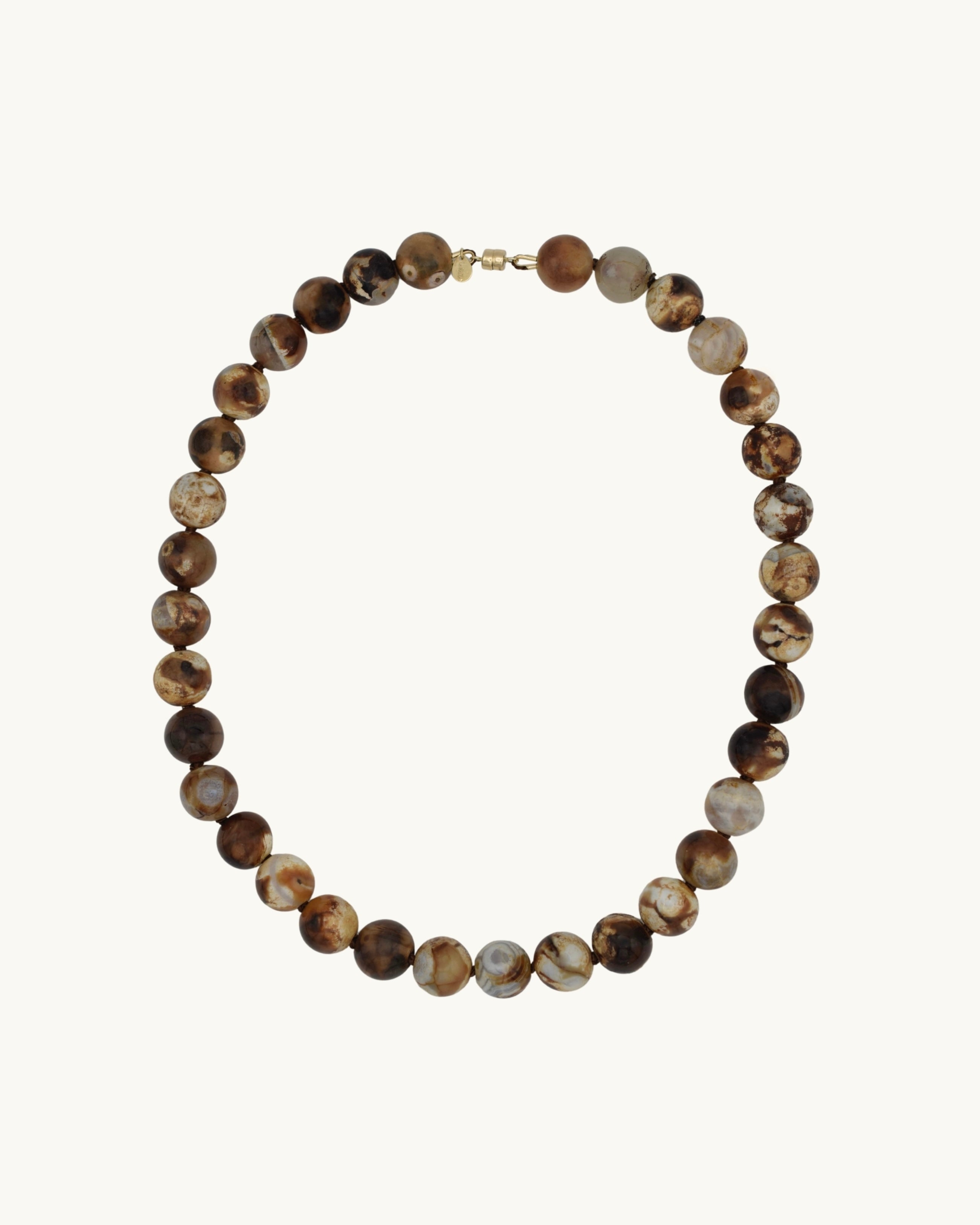 Beaded necklace with brown and beige stones on a white background with gold magnetic clasp