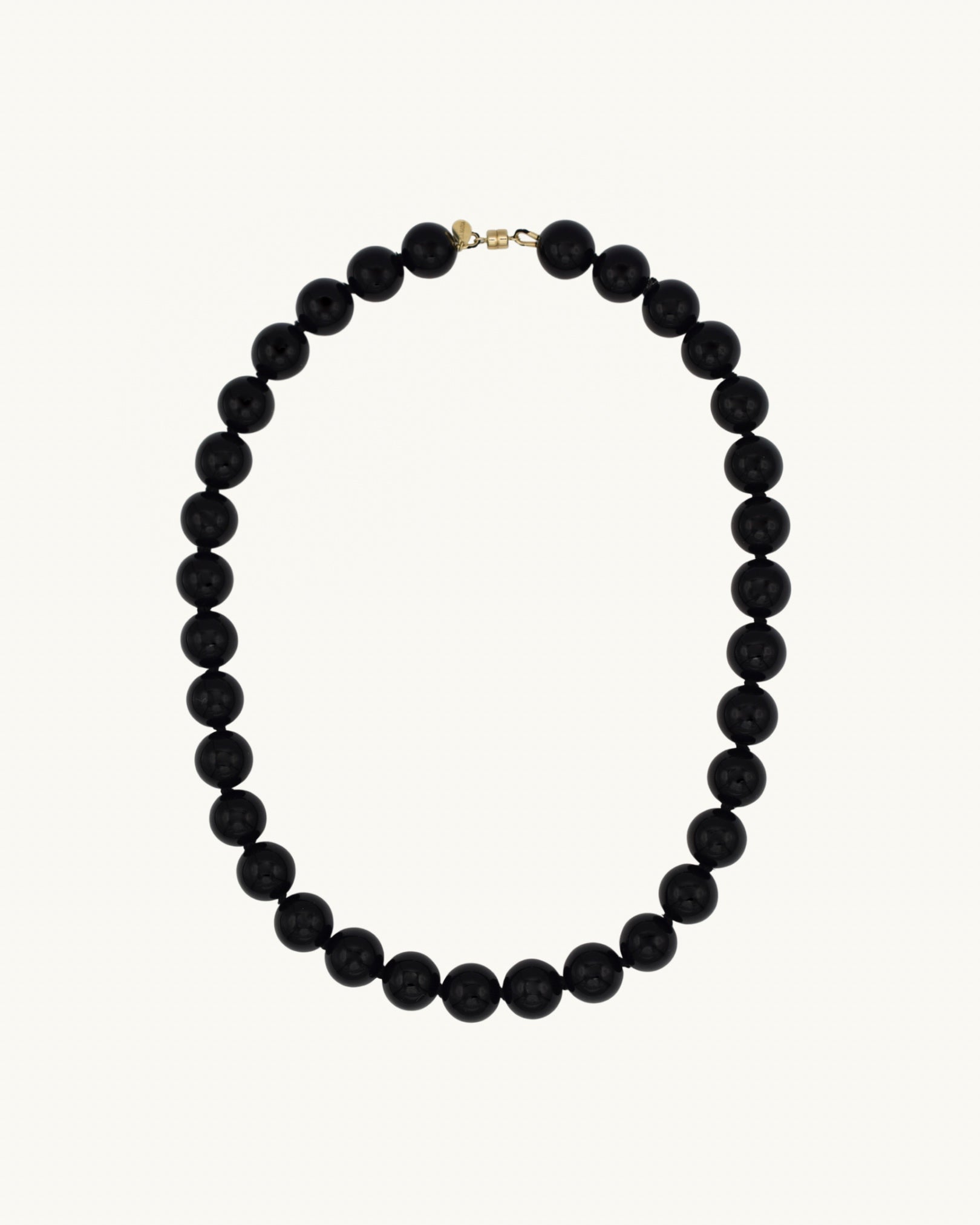 Black beaded necklace on a white background with a gold magnetic clasp