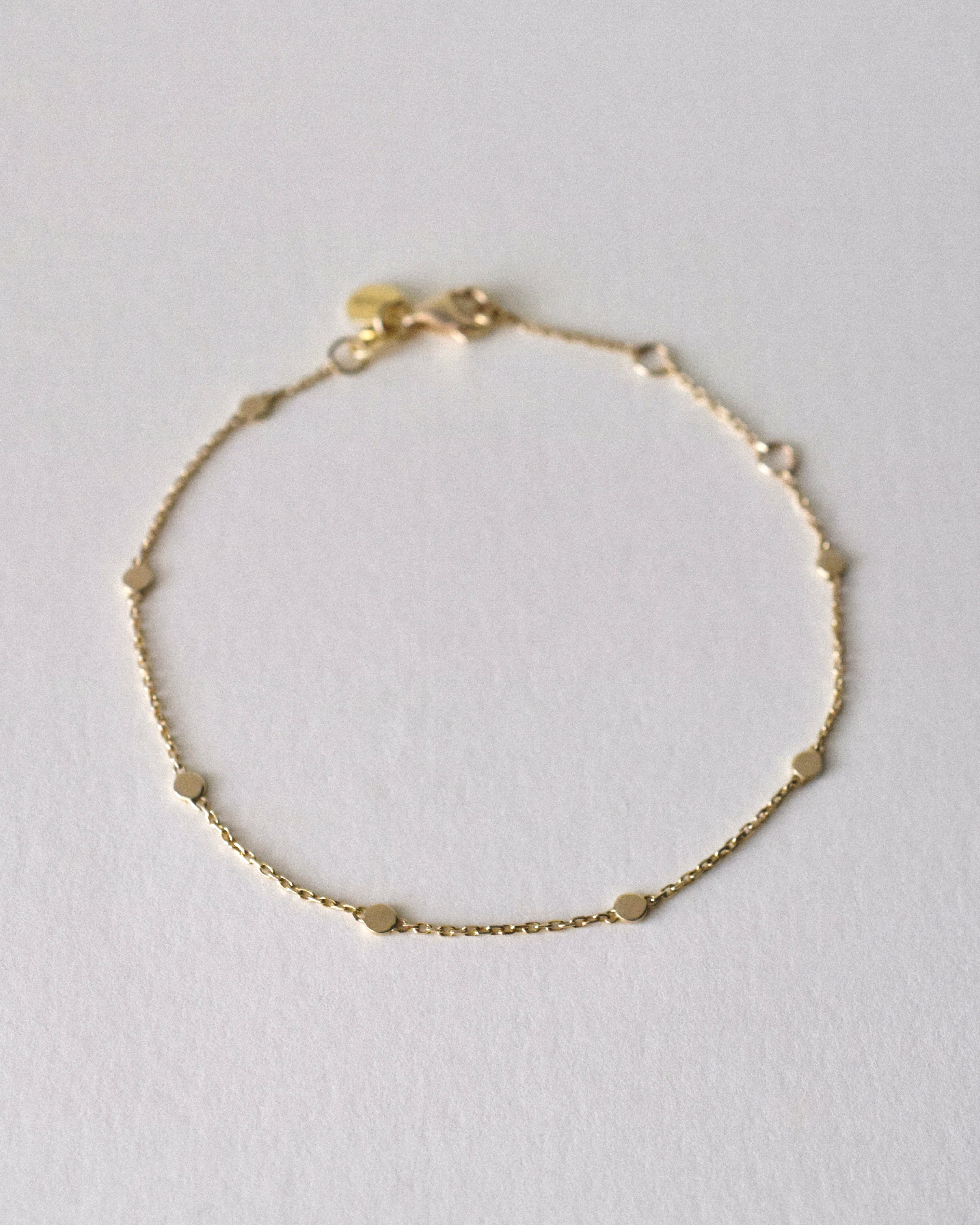 Gold bracelet on a light gray background
