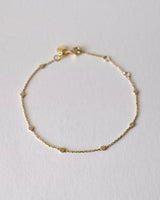 Gold bracelet on a light gray background