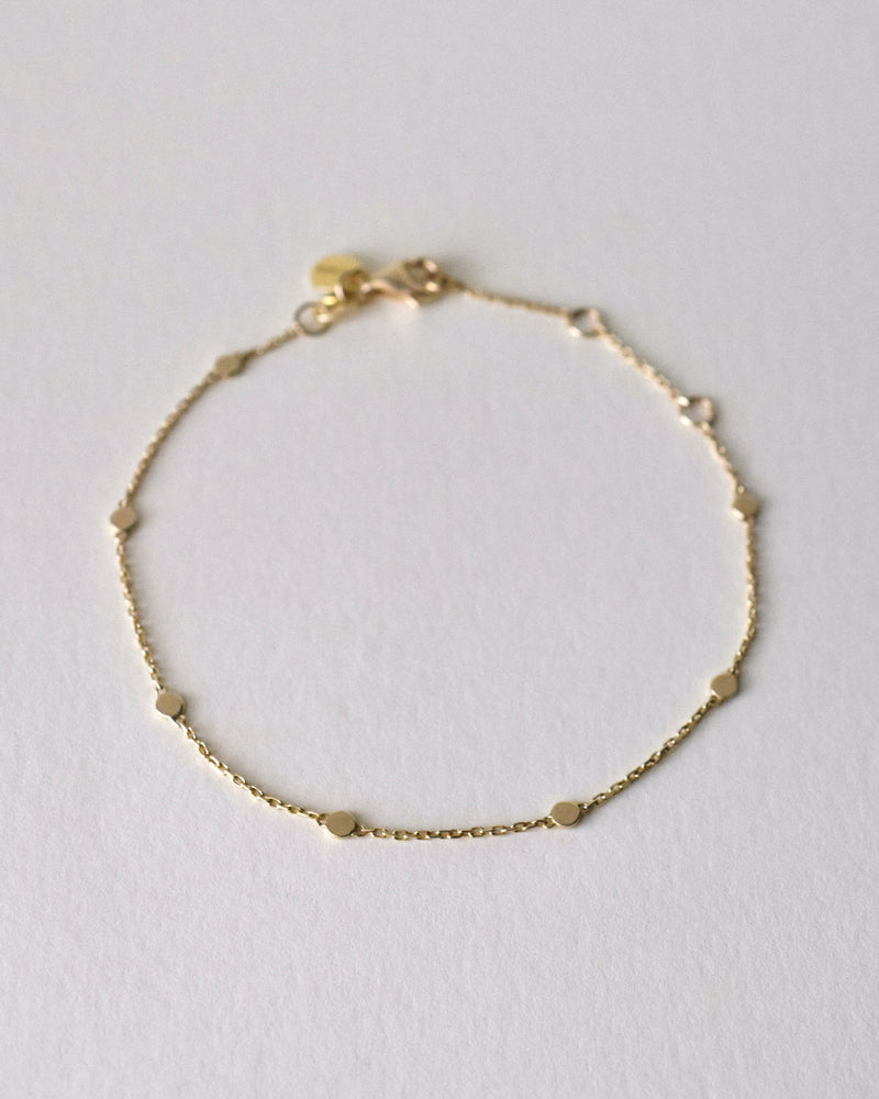 Gold bracelet on a light gray background