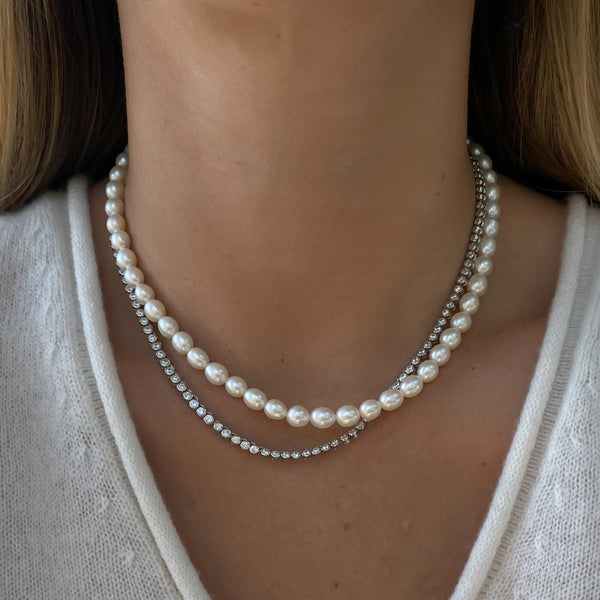 model wearing the claire pearl necklace paired with the vivienne tennis necklace in silver with zirconia stones