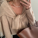 model wearing the claire pearl necklace style with a cashmere jumper tied over the shoulders